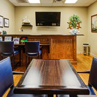 A well-arranged meeting room with a wooden table, chairs, and a television mounted on the wall.