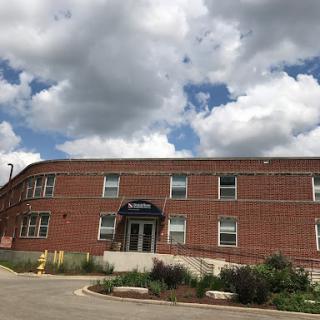 A brick building under a partly cloudy sky.