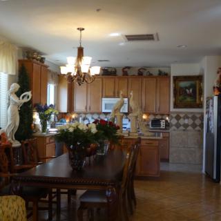 A spacious kitchen with wooden cabinets, a dining table set, and elegant decor.