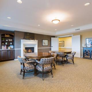 A cozy living room with a fireplace, dining table, and bookshelves.