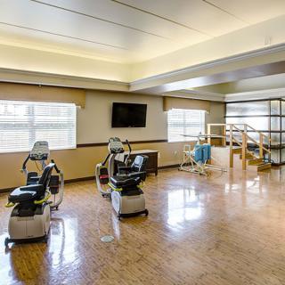 A spacious rehabilitation center with therapy chairs and exercise equipment.