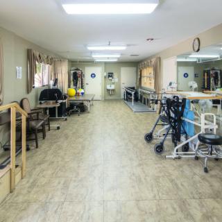 An empty rehabilitation center with physical therapy equipment and exercise aids.