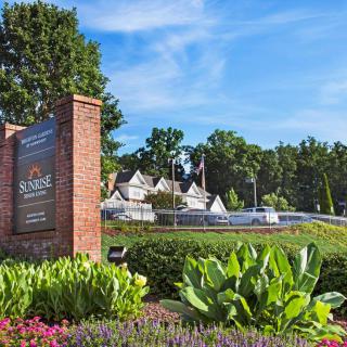 Entrance to Reynolda Village with landscaped gardens and surrounding trees.
