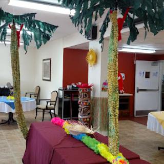 A festive indoor setting decorated with vibrant palm tree props for a celebration.