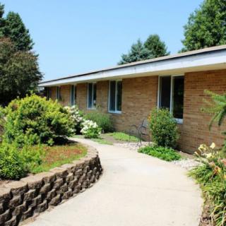 A brick house with a well-maintained garden and a curving pathway.