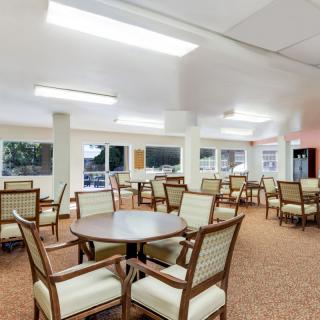 A spacious and well-lit dining area with multiple tables and chairs.