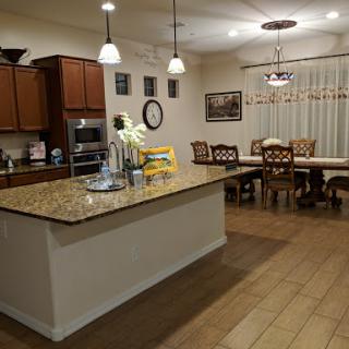 A spacious kitchen and dining area featuring modern decor, elegant furniture, and warm lighting.