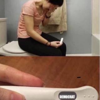 A woman reacts emotionally while holding a pregnancy test in a bathroom.