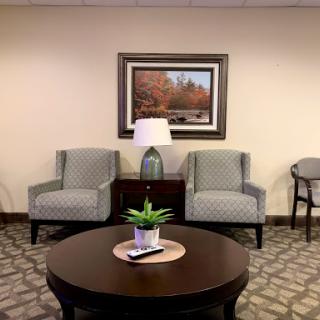 A cozy and inviting waiting area featuring comfortable chairs, a stylish coffee table, and decorative elements.