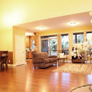 A spacious living room featuring warm tones, modern furniture, and abundant natural light.