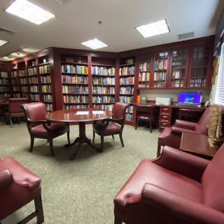 A cozy library with wooden bookshelves and comfortable seating.