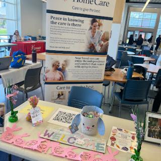 A vibrant table setup for a healthcare organization, featuring informational materials, a donation jar, and a welcoming atmosphere at a community event.