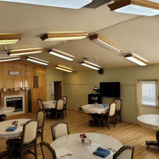 A cozy dining area featuring round tables, comfortable chairs, and plenty of natural light from skylights.