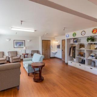Spacious lounge area with comfortable seating and decorative shelves.