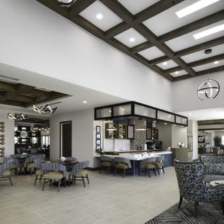 A modern and spacious cafe interior with a variety of seating options and stylish lighting.