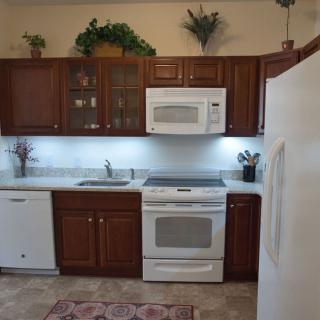 A modern kitchen with wooden cabinets and white appliances.