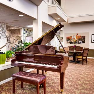 A cozy interior featuring a grand piano and seating area.