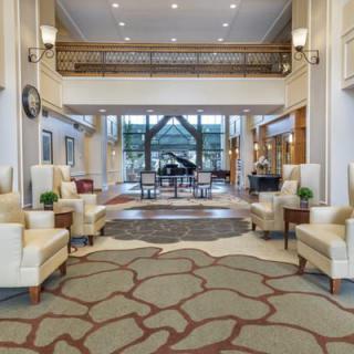 A modern and luxurious hotel lobby featuring elegant seating, a grand piano, and sophisticated decor.
