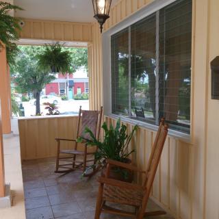 A cozy porch with rocking chairs and lush plants.