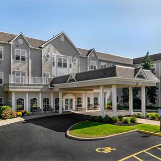 Front view of a hotel with a welcoming entrance and landscaped surroundings.