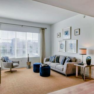 A well-lit living room with a sofa, armchair, and modern decor.