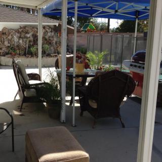 A cozy backyard patio with outdoor seating and a canopy.