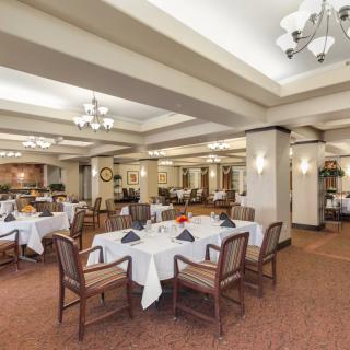 A spacious and elegantly decorated restaurant dining area with neatly arranged tables and chairs.