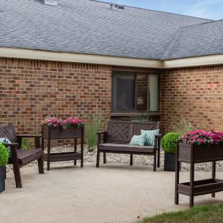 A cozy outdoor patio area featuring comfortable seating and vibrant flower arrangements.
