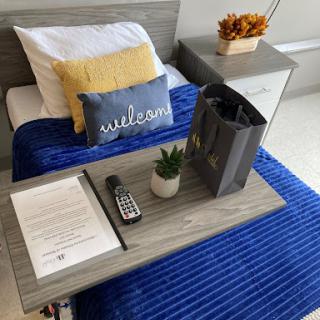 A welcoming and cozy setup featuring a neatly made bed, decorative pillows, and thoughtful touches for comfort.
