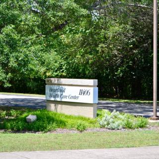 A sign at the entrance of a nature park surrounded by lush greenery.
