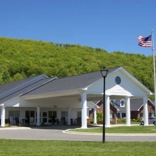 A white pavilion-style building with an American flag in a scenic, green environment.