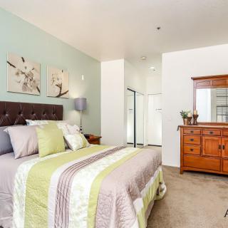 A cozy bedroom with a neatly made bed and stylish decor.