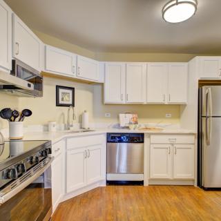 A modern kitchen with white cabinets and stainless steel appliances.