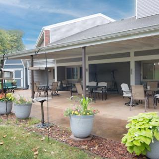 A serene outdoor patio space featuring comfortable seating and vibrant potted plants.