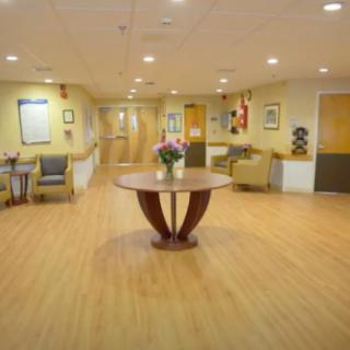 A well-lit lobby with seating and a central table decorated with flowers.