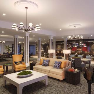 A spacious and elegantly designed living room featuring comfortable seating and modern lighting.