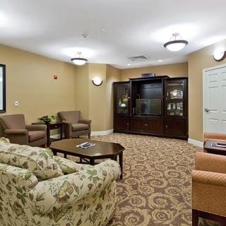 A cozy lounge area with comfortable seating, a patterned carpet, and soft lighting.
