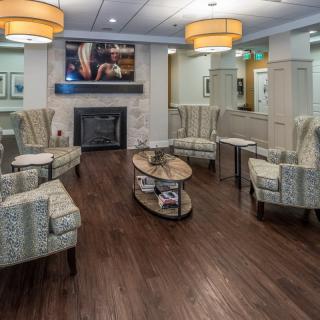 A cozy lobby seating area with comfortable chairs, a fireplace, and warm lighting.