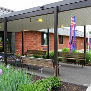 A building entrance with benches and patriotic decorations.