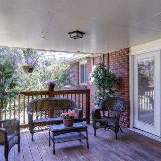 A cozy outdoor patio with seating and plants.