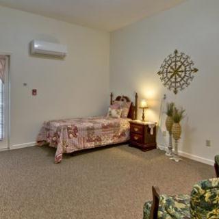 A cozy bedroom with a single bed, nightstand, and decorative elements on the wall.