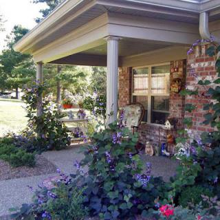 A beautifully landscaped house porch adorned with vibrant flowers.