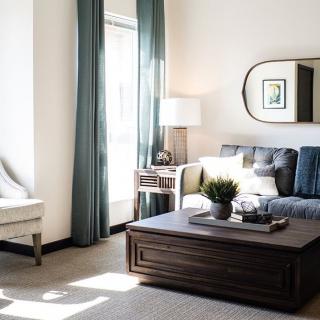 A modern living room featuring a comfortable sofa, large coffee table, and abundant natural light.