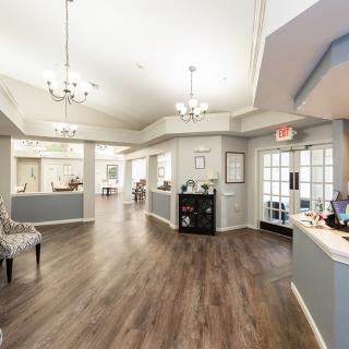 A bright and spacious lobby area with elegant chandeliers and hardwood flooring.