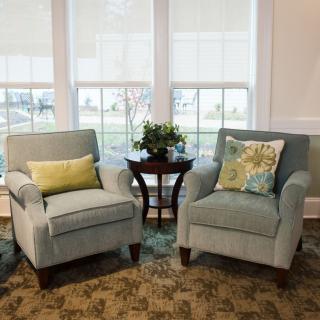 A cozy seating area with two armchairs and a small side table by the window.