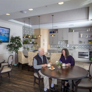 Two people enjoying a meal in a modern kitchen and dining area.