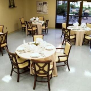 A dining area with round tables and chairs set up for an event or meal.