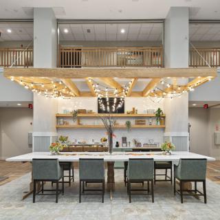A modern hotel lobby with a stylish seating area, featuring wood accents and decorative lighting.
