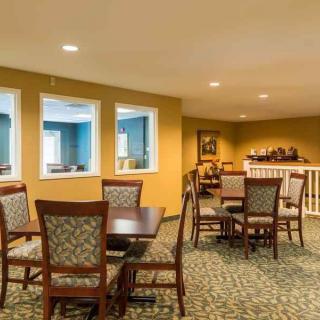 A cozy dining area with tables and chairs arranged on a carpeted floor.