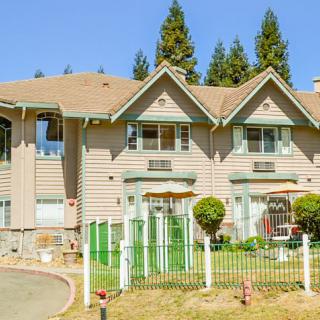 A suburban house with a well-maintained lawn and trees in the background.